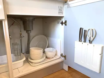 a cupboard with dishes and utensils in a kitchen at Wing Stay in Tokyo