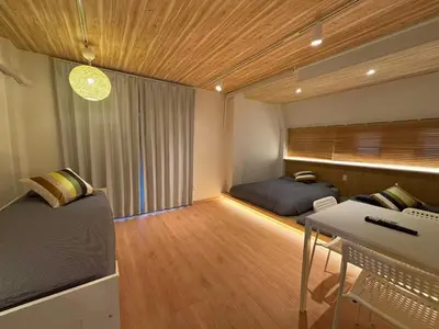 a bedroom with two beds and a desk in it at Wing Stay in Tokyo