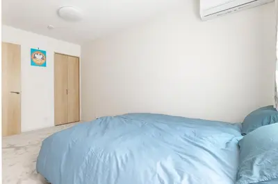 a bedroom with a blue bed in a white room at Featured Japanese Culture Hut Experience Tokyo's Local Life in a Two-Story Detached B&B in Tokyo
