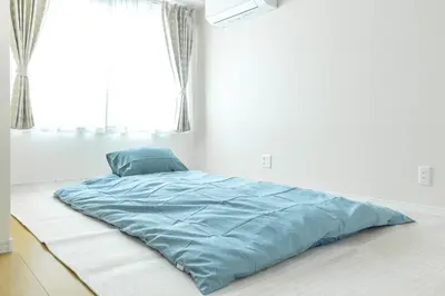 a bed in a white room with a blue blanket at Featured Japanese Culture Hut Experience Tokyo's Local Life in a Two-Story Detached B&B in Tokyo