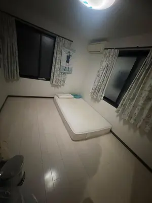 a small room with a mattress on the floor and two windows at sakura\u306e\u5bb6 in Tokyo