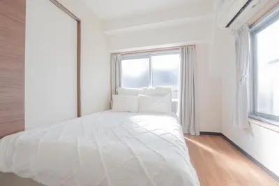 a white bedroom with a large bed and windows at \u65b0\u5bbf\u99c5\u30a8\u30ea\u30a2\u5f92\u6b69\u570f \u4ea4\u901a\u81f3\u4fbf \u89b3\u5149 \u30b7\u30e7\u30c3\u30d4\u30f3\u30b0 \u30b0\u30eb\u30e1\u306b\u6700\u9069\u306a\u5317\u65b0\u5bbf\u30b9\u30c6\u30a4 in Tokyo