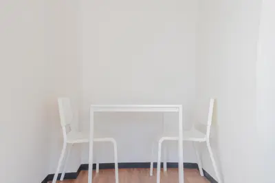 a glass table and two white chairs in a room at \u65b0\u5bbf\u99c5\u30a8\u30ea\u30a2\u5f92\u6b69\u570f \u4ea4\u901a\u81f3\u4fbf \u89b3\u5149 \u30b7\u30e7\u30c3\u30d4\u30f3\u30b0 \u30b0\u30eb\u30e1\u306b\u6700\u9069\u306a\u5317\u65b0\u5bbf\u30b9\u30c6\u30a4 in Tokyo