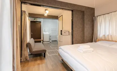a bedroom with a bed and a chair in it at Marble TOKYO Base Tabata 102 in Tokyo