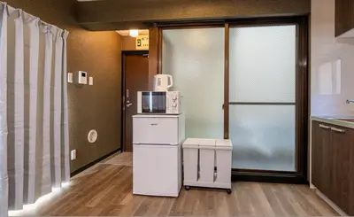 a kitchen with a microwave on top of a refrigerator at Marble TOKYO Base Tabata 202 in Tokyo