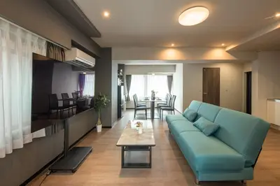 a living room with a blue couch and a table at Ebisu City Stay 5F - \u6075\u6bd4\u5bff \u30b7\u30c6\u30a3\u30b9\u30c6\u30a4 5F in Tokyo