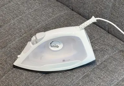 a white iron sitting on top of a couch at Marble TOKYO Base Tabata 201 in Tokyo