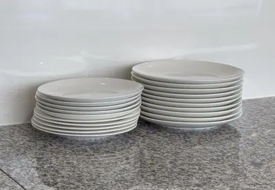 two stacks of white plates sitting on a table at Marble TOKYO Base Tabata 201 in Tokyo