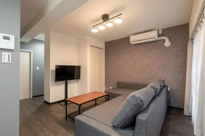 a living room with a couch and a tv at Marble TOKYO Base Tabata 201 in Tokyo