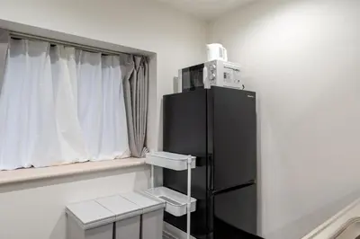 a black refrigerator in a room with a window at Marble TOKYO Base Tabata 201 in Tokyo