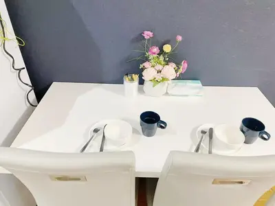 a white table with white cups and flowers on it at \u30b5\u30af\u30e9\u30b7\u30e3\u30c9\u30a6\u767d\u91d1203 in Tokyo
