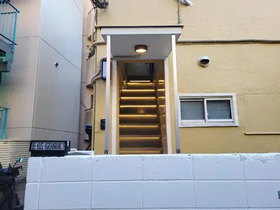 a stairway to a building with a gold door at 2F TINY Central Apartment 7 minutes from Shinjuku in Tokyo