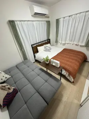 a bedroom with a bed and a couch in it at 5 minutes on foot from Otsuka Station on the Yamanote Line, with excellent access to major areas such as Ikebukuro, Shinjuku, and Ueno! in Tokyo