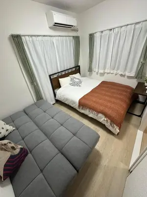 a bedroom with a bed and a large ottoman at 5 minutes on foot from Otsuka Station on the Yamanote Line, with excellent access to major areas such as Ikebukuro, Shinjuku, and Ueno! in Tokyo