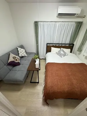 a bedroom with a bed and a couch at 5 minutes on foot from Otsuka Station on the Yamanote Line, with excellent access to major areas such as Ikebukuro, Shinjuku, and Ueno! in Tokyo