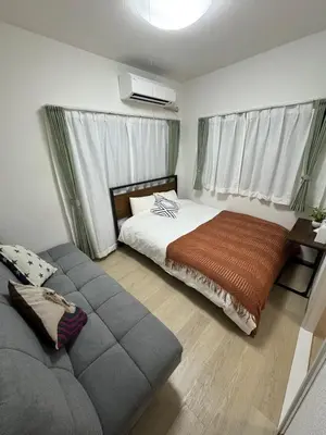 a bedroom with a bed and a couch at 5 minutes on foot from Otsuka Station on the Yamanote Line, with excellent access to major areas such as Ikebukuro, Shinjuku, and Ueno! in Tokyo