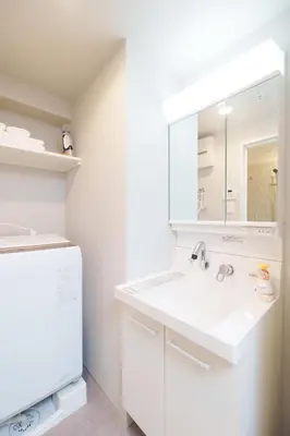 a white bathroom with a sink and a mirror at Hotel ONE in Tokyo