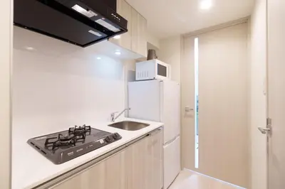 a kitchen with a sink and a white refrigerator at Hotel ONE in Tokyo