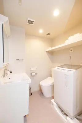 a white bathroom with a toilet and a sink at Hotel ONE in Tokyo