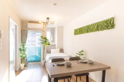 a living room with a table and a bed at 5 min walk to station, New building, 15 m Meguro River in Tokyo