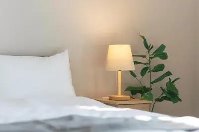 a lamp on a night stand next to a bed at 5 min walk to station, New building, 15 m Meguro River in Tokyo