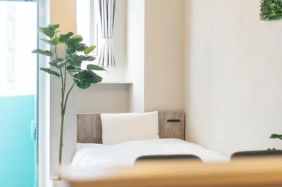 a bedroom with a white bed and a plant at 5 min walk to station, New building, 15 m Meguro River in Tokyo
