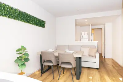 a dining room with a table and chairs and a couch at 5 min walk to station, New building, 15 m Meguro River in Tokyo