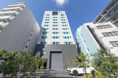 a white car parked in front of two tall buildings at 5 min walk to station, New building, 15 m Meguro River in Tokyo