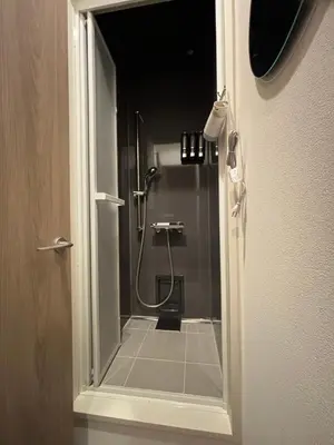 a bathroom with a shower with a glass door at BEDandBAR MIDUKI \u30db\u30b9\u30c6\u30eb in Tokyo