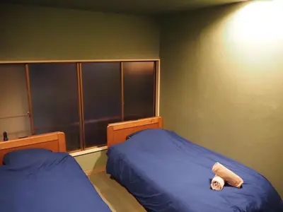 a bedroom with two beds and a head board at BEDandBAR MIDUKI \u30db\u30b9\u30c6\u30eb in Tokyo