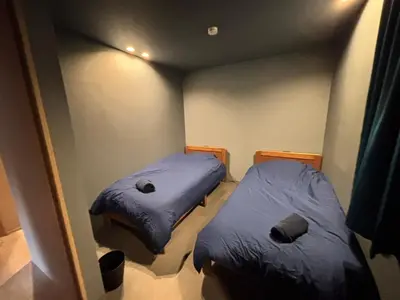two beds in a room with blue blankets at BEDandBAR MIDUKI \u30db\u30b9\u30c6\u30eb in Tokyo