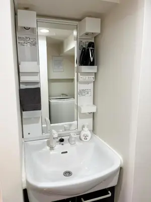 a bathroom with a white sink and a mirror at 2F Spacious Apartment in Shinjuku, Shibuya Tokyo in Tokyo