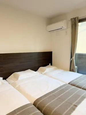 two twin beds in a bedroom with a window at ISSHUKU NOMA\u6c60\u888bII 203 - Quad Room in Tokyo