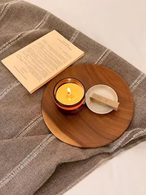 a candle in a bowl on a wooden plate at ISSHUKU NOMA\u6c60\u888bII 205 - Quad Room in Tokyo