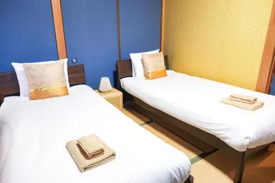 two beds in a small room with white sheets at Urban Hills IKEBUKURO 51sqm Big 1LDK 5people Beautiful Japanese Interior in Tokyo