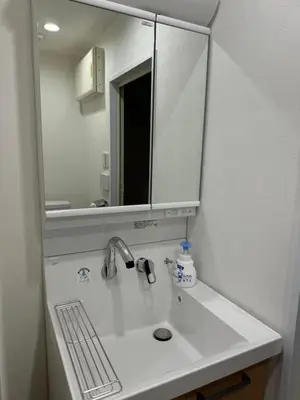 a bathroom with a sink and a mirror at C&H hotel1F in Tokyo