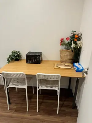 a wooden table with two chairs and flowers on it at C&H hotel1F in Tokyo