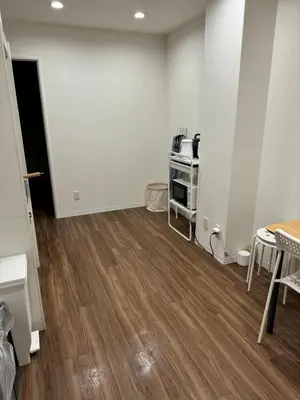 a room with white walls and a wooden floor at C&H hotel1F in Tokyo