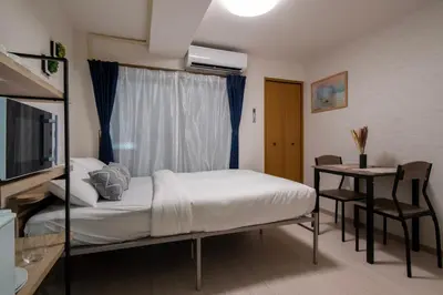 a bedroom with a bed and a television and a table at CraftFlat Numabukuro 303, uphill residence in Tokyo
