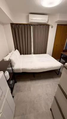 a small room with a bed with a curtain at CraftFlat Numabukuro 303, uphill residence in Tokyo