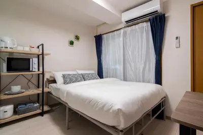 a small bedroom with a bed and a window at CraftFlat Numabukuro 303, uphill residence in Tokyo