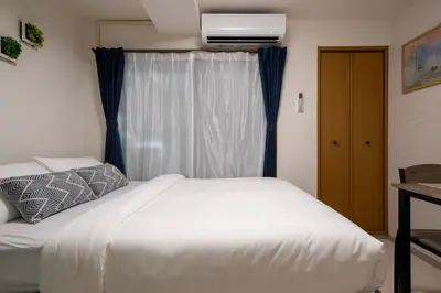 a bedroom with a white bed and a window at CraftFlat Numabukuro 303, uphill residence in Tokyo