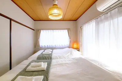 a bedroom with a large bed with towels on it at F-City \u4e2d\u845b\u897f I in Tokyo