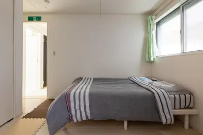 a bedroom with a bed in a room with a window at Haneda Hub 7km to HND- 6min Walk to Omori Stn in Tokyo