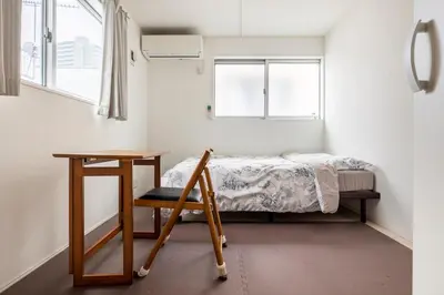 a bedroom with a bed and a table and a chair at Haneda Hub 7km to HND- 6min Walk to Omori Stn in Tokyo