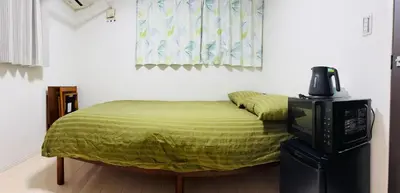 a bedroom with a bed with a television and a window at Haneda Hub 7km to HND- 6min Walk to Omori Stn in Tokyo