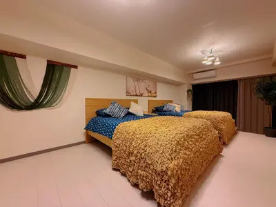 a bedroom with two beds with blue and gold sheets at TokyoShinjuk Station800meterskabukicho2minutes101 in Tokyo