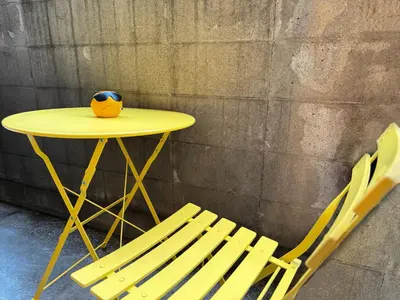 a yellow table with a vase on it next to a chair at TokyoShinjuk Station800meterskabukicho2minutes101 in Tokyo