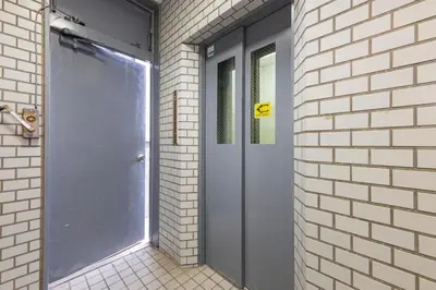 a blue door in a brick building with a window at \u30a8\u30c9\u30e2\u30c0\u30f3\u30b9\u30c6\u30a4 Edo Modern Stay 02 in Tokyo