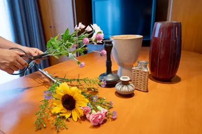 a person cutting a flower arrangement on a wooden table at Japanese life with garden, 2BR, feel & enjoy seasons in Tokyo